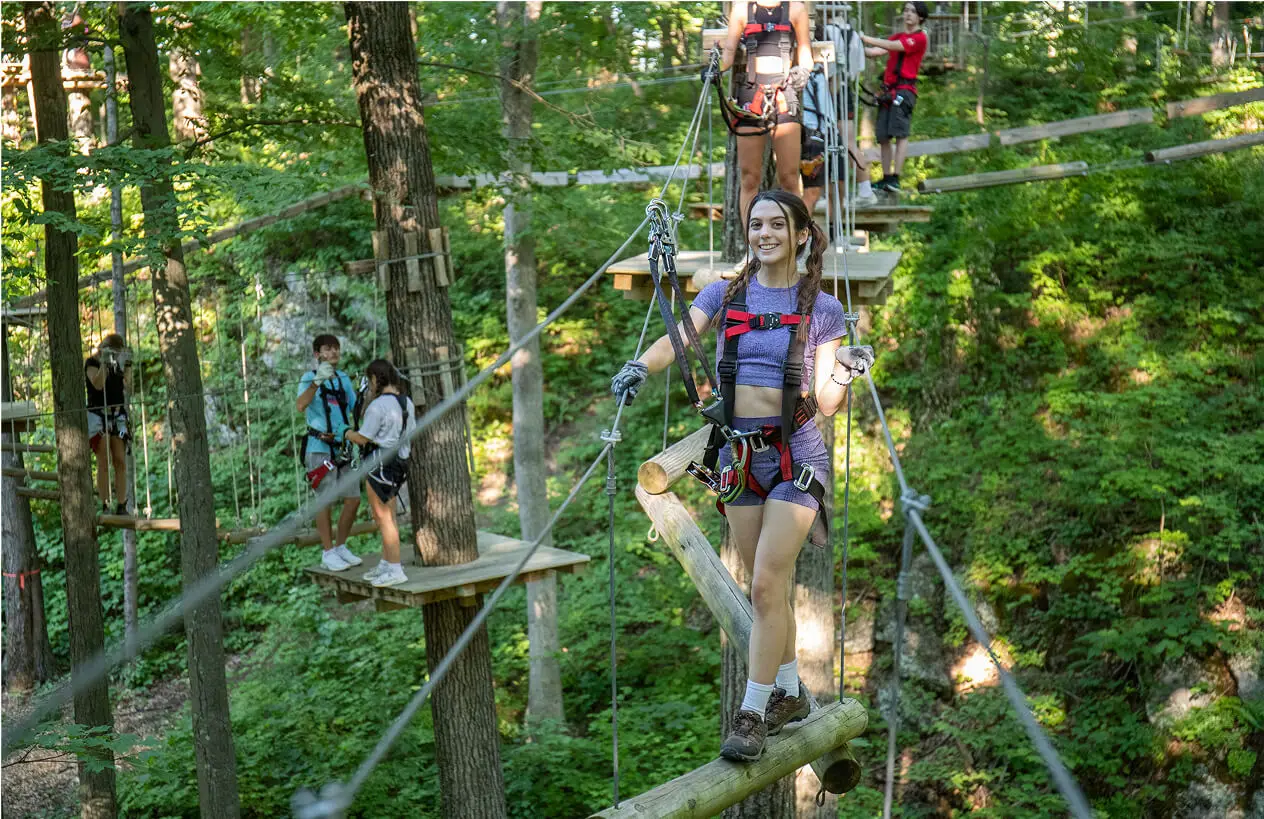 Young people on the aerial ropes course at TreEscape Aerial Adventure Park, Vernon, New Jersey. Aerial ropes Course New Jersey