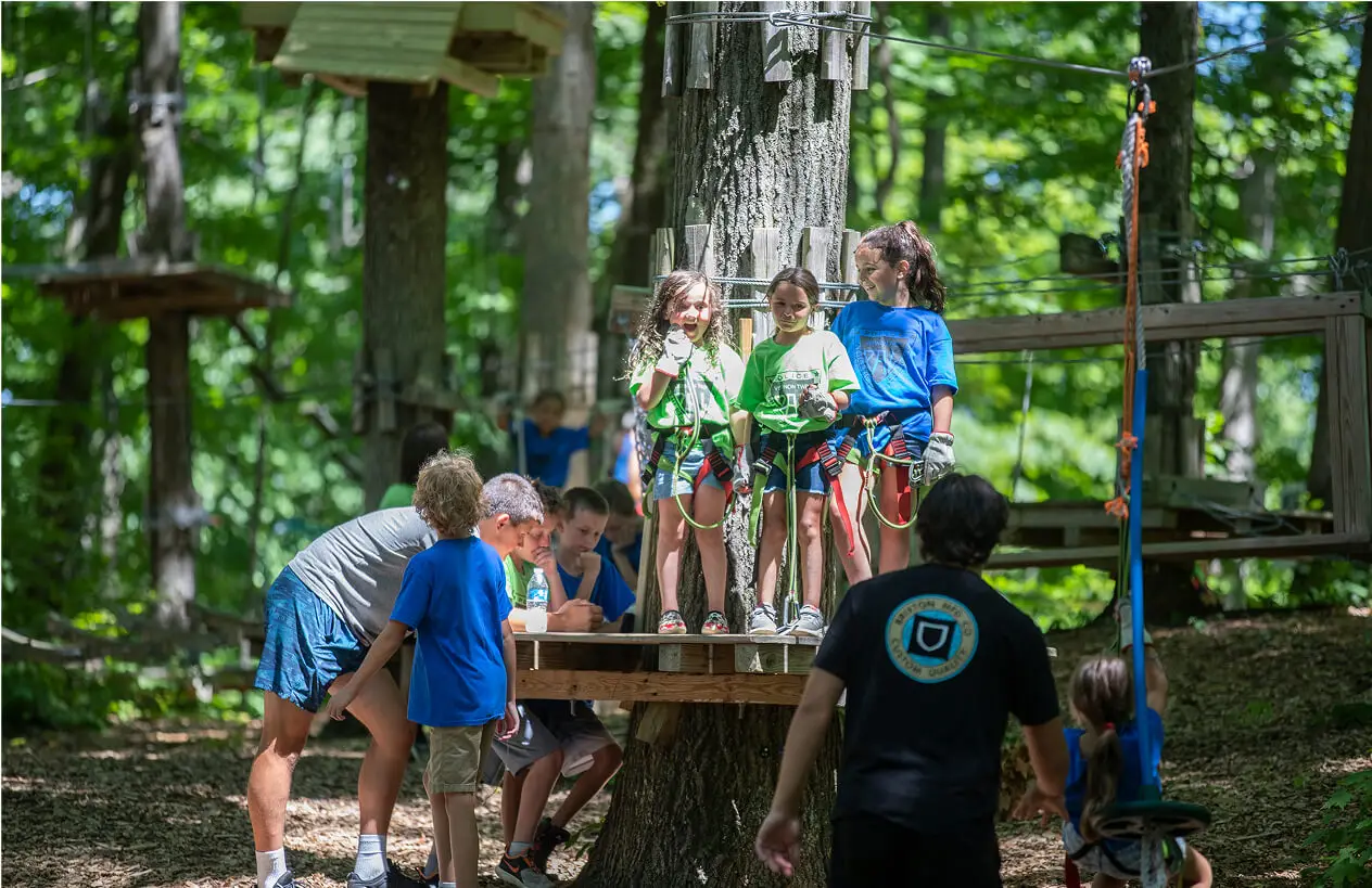 Kids gearing up and eagerly waiting before their zip line adventure at TreEscape Park in Vernon, NJ, filled with excitement and anticipation for the thrill ahead.