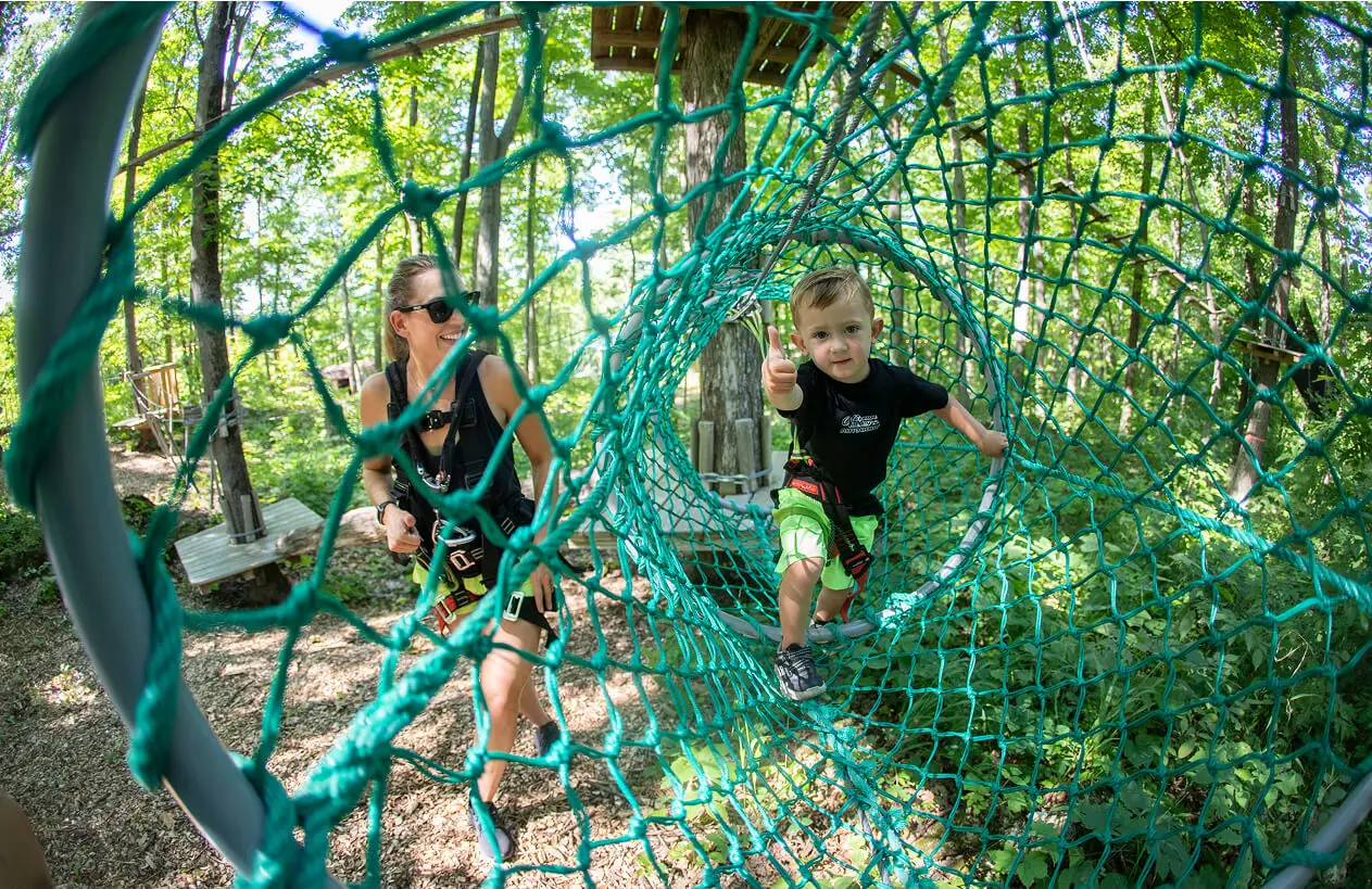 Young child happily spending time with her mother at TreEscape Park in Vernon, NJ, enjoying the outdoors. Symbot of obstacle courses near me in Vernon, NJ.
