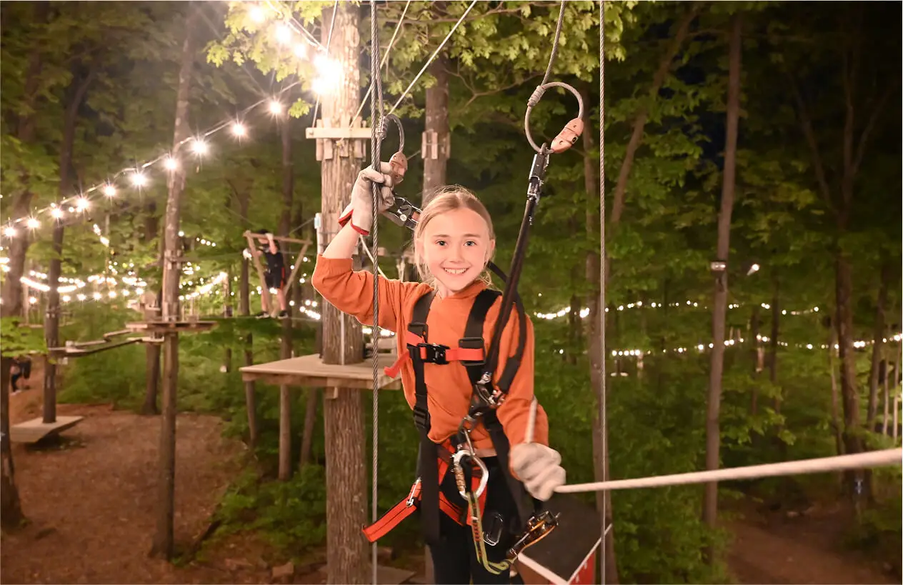Girl excitedly posing at TreEscape Park in Vernon, NJ, ready for an adventure and thrilled to experience the outdoor challenges and fun activities.