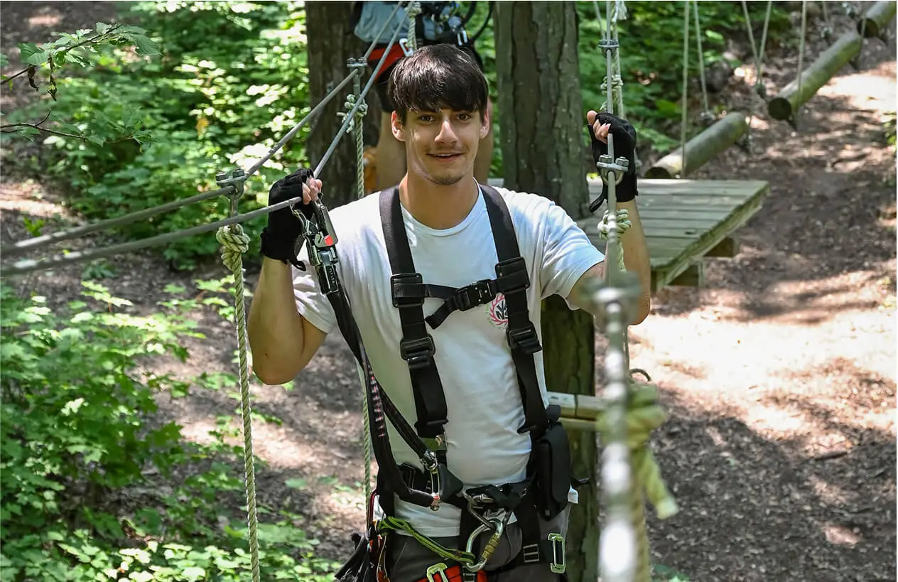 Navigating aerial ropes course at TreEscape NJ on a summer day.