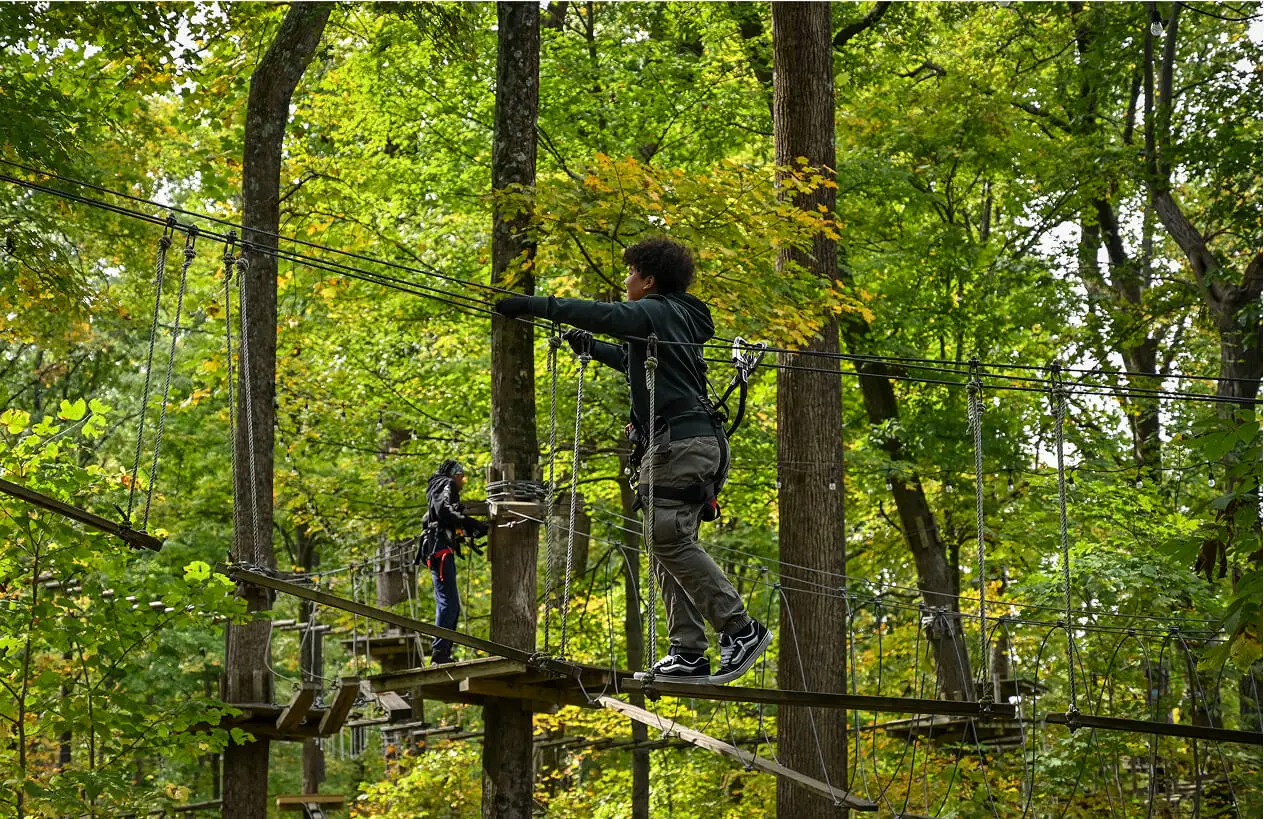 Boy navigating the aerial ropes course at TreEscape Park in Vernon, NJ, embracing the challenge and enjoying the thrill of the outdoor adventure.