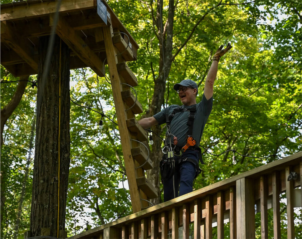 Man preparing to launch on a zip line at TreEscape aerial adventure park in Vernon, NJ. Outdoor wellness at TreEscape
