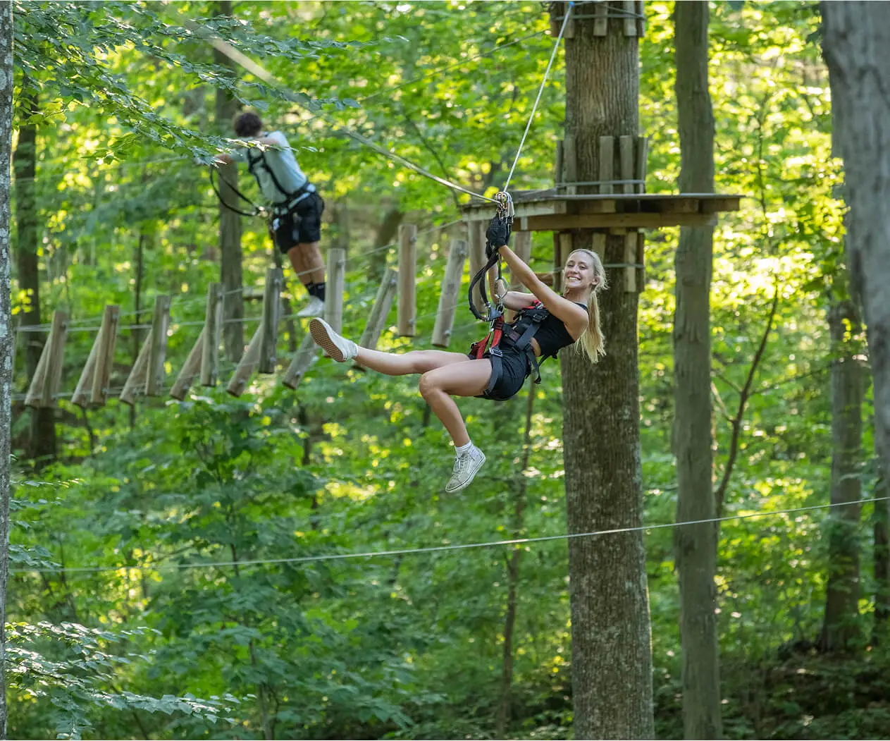 young woman navigating on a zip line at TreEscape Aerial adventure park