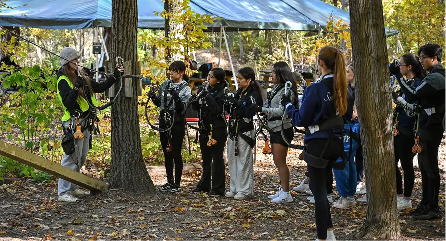 Kids and their teacher exploring TreEscape Park in Vernon, NJ, taking in the natural beauty and participating in outdoor activities during their school field trip.