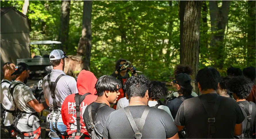 Group of people working together on a team-building activity at TreEscape Park in Vernon, NJ, collaborating and having fun while strengthening teamwork skills in the great outdoors.