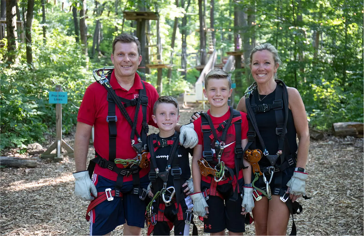Family posing together at TreEscape Park in Vernon, NJ, smiling and enjoying a memorable day of outdoor fun and adventure. ropes course near me, NJ