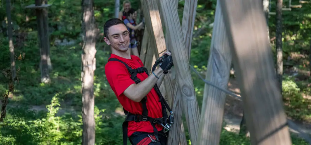 Young man at TreEscape Park in Vernon, NJ, smiling and enjoying a fun day of outdoor adventure.
