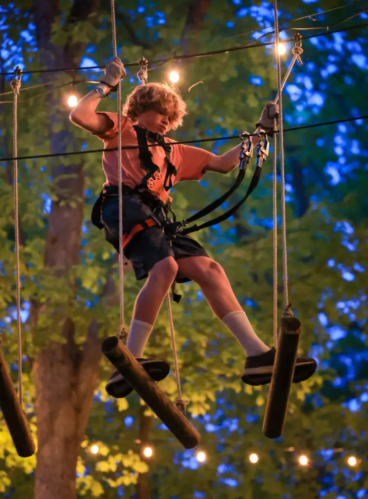 Kid on the ropes courses after dark at TreEscape Aerial Adventure Park.