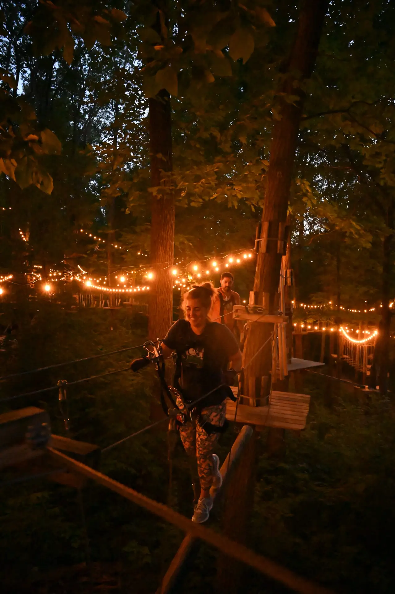 Woman participating in a nighttime ropes course at TreEscape Vernon, NJ>