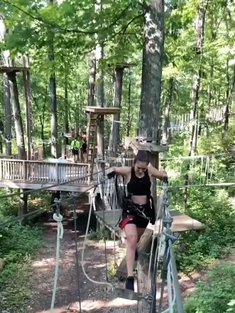Woman navigating an aerial ropes course at TreEscape in Vernon, NJ.