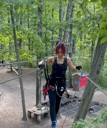 Woman influencer navigating an aerial ropes course at TreEscape in Vernon, NJ.