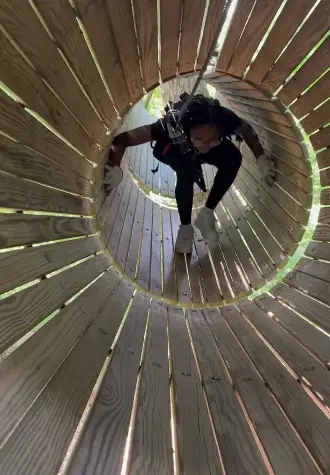 Woman influencer navigating obstacle courses at TreEscape Adventure Park, Vernon, NJ.