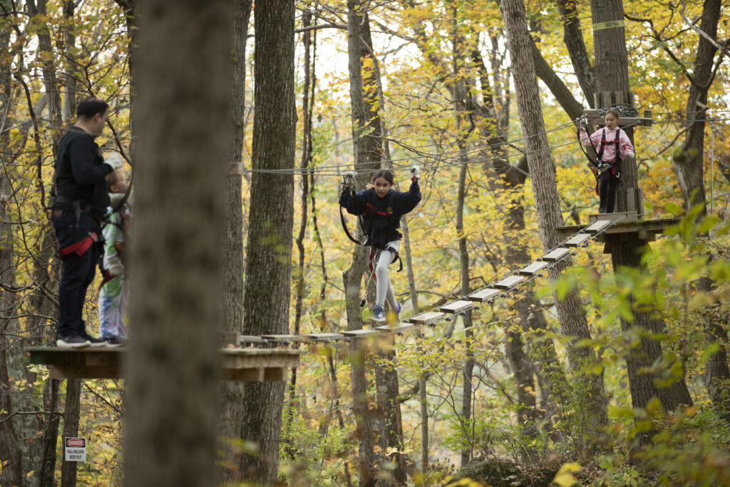 Kids navigating aerial ropes courses in September at TreEscape Aerial Adventure Park, places to visit in New Jersey this fall. 