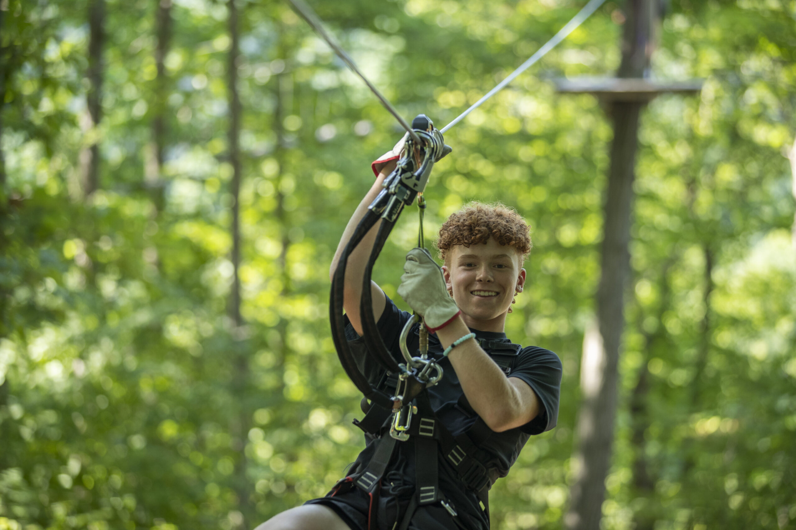 Excited child soaring on a zip line at TreEscape Aerial Adventure Park, enjoying one of New Jersey’s top eco-friendly outdoor adventures surrounded by lush forest.