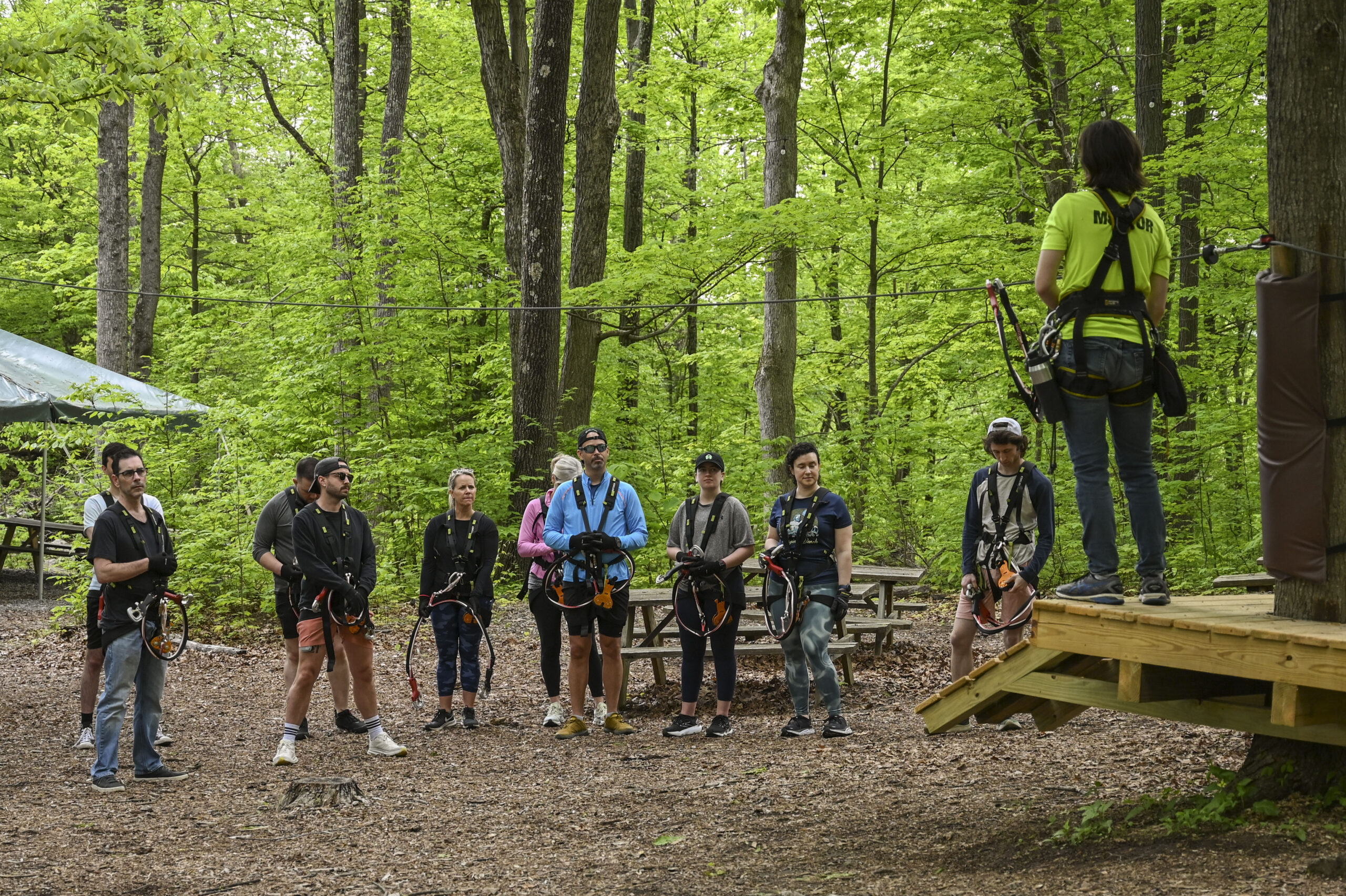 Group of young people at TreEscape Adventure Park, preparing for zip line in teh forest